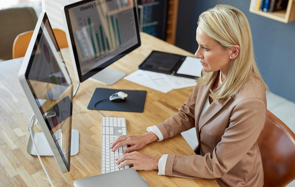 Woman working at a desktop computer in an office.